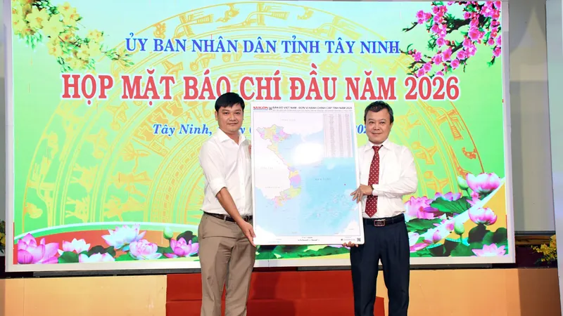 Nhà báo Phạm Minh Tuấn Vũ, Phó trưởng Phụ trách Văn phòng đại diện Báo Sài Gòn Giải Phóng khu vực ĐBSCL (trái) trao bản đồ Việt Nam tặng đại diện tỉnh Tây Ninh. Ảnh: Quang Vinh
