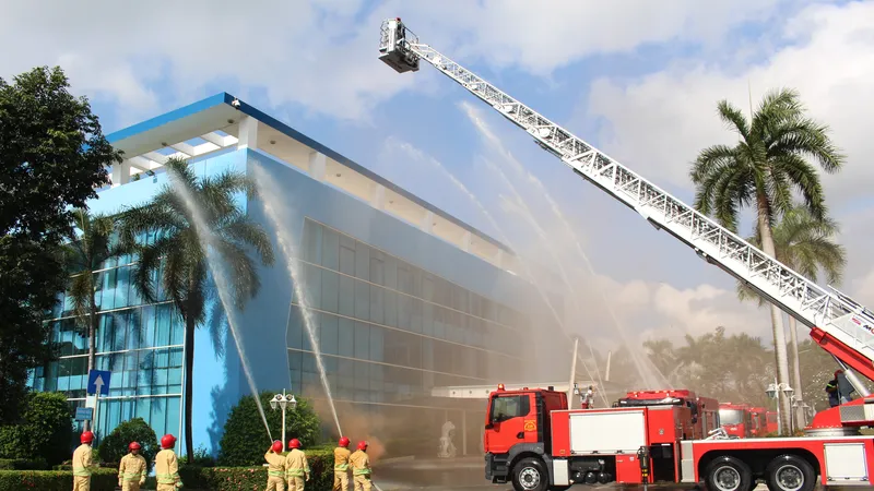 Lực lượng Cảnh sát PCCC-CNCH phối hợp với lực lượng PCCC cơ sở VWS triển khai phương tiện, phun nước từ xe thang trong tình huống diễn tập tại Khu liên hợp Đa Phước.