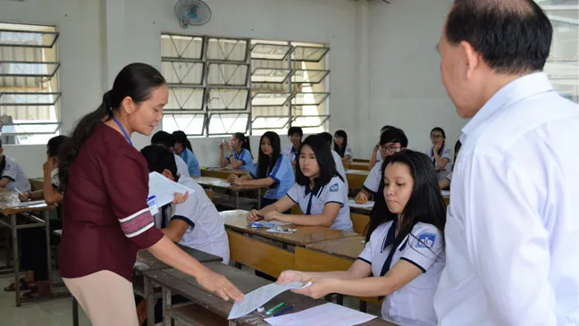 Giám thị phát đề thi cho thí sinh thi môn Ngoại ngữ. Ảnh: Thanh Hùng