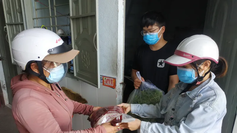 Công nhân ở khu nhà trọ nhận quà hỗ trợ vì dịch Covid-19. Ảnh: MINH NGHĨA