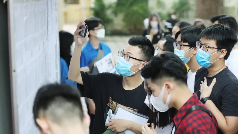 Thí sinh xem thông tin ở khu vực niêm yết danh sách thí sinh dự thi, nghe quy chế tại điểm thi Trường THPT Phan Đình Phùng, Hà Nội, chiều 6-7. Ảnh: VIẾT CHUNG 