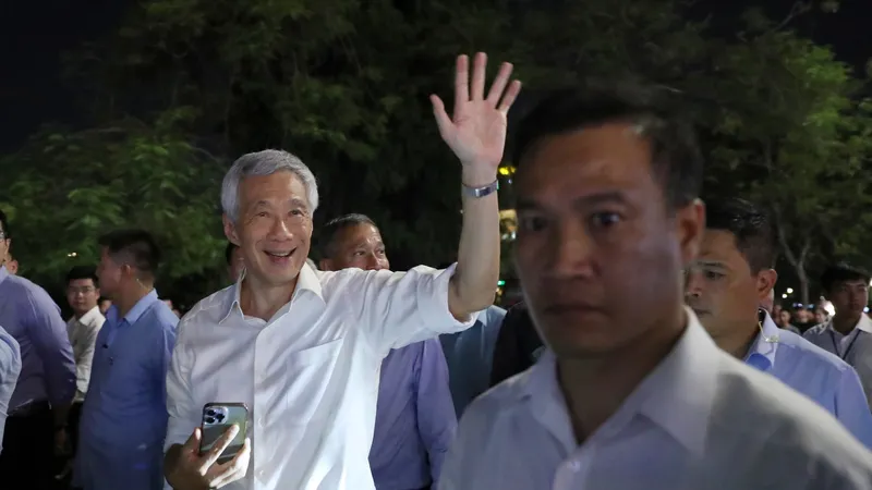 Thủ tướng Singapore Lý Hiển Long chào người dân khi dạo phố đi bộ bên hồ Hoàn Kiếm và thăm đền Ngọc Sơn, tối 27-8. Ảnh: QUANG PHÚC