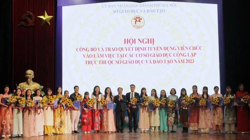 Sở GD-ĐT Hà Nội trao quyết định tuyển dụng và tặng hoa cho các giáo viên.