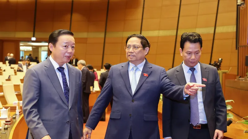 Thủ tướng Phạm Minh Chính trao đổi với Phó Thủ tướng Trần Hồng Hà và Bộ trưởng Bộ TN-MT tại phiên họp Quốc hội thảo luận về dự thảo Luật Đất đai (sửa đổi) sáng 15-1. Ảnh: QUANG PHÚC
