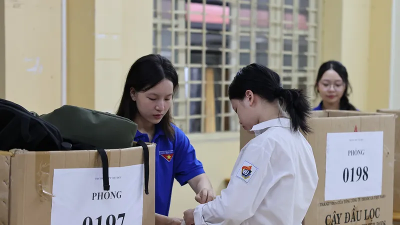 Sinh viên tình nguyện hỗ trợ thí sinh cất đồ đạc cá nhân tại điểm thi Trường THPT Việt Đức, quận Hoàn Kiếm, Hà Nội. Ảnh: QUANG PHÚC 