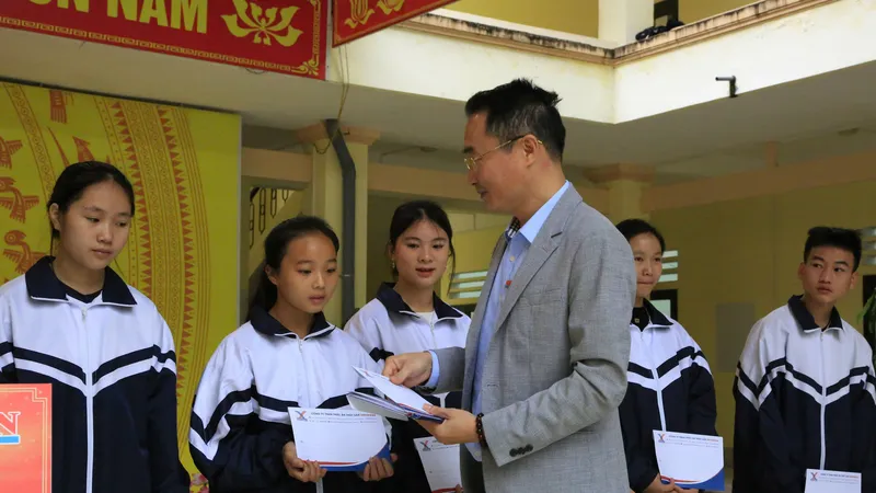 Ông Đỗ Ngọc Quang, Phó trưởng phụ trách Văn phòng đại diện Báo Sài Gòn Giải Phóng tại Hà Nội, trao học bổng đến các em học sinh. Ảnh: HÀ NGUYỄN