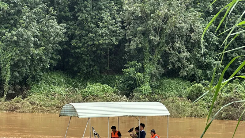 Quan trắc viên Trạm thuỷ văn Phước Hoà đang tiến hành các bước để đo lưu lượng dòng chảy trên sông. Ảnh: THANH HIỀN