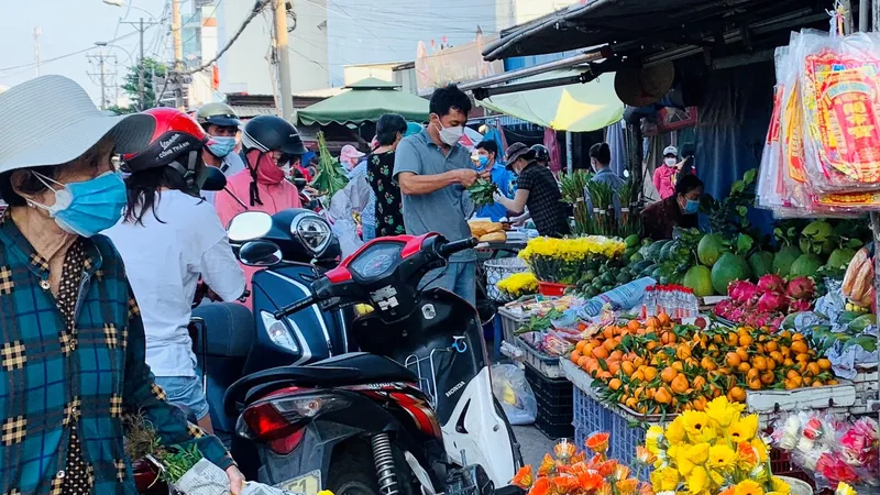 Khách đi chợ mua trái cây, hoa tươi vía Thần Tài. Ảnh: THI HỒNG
