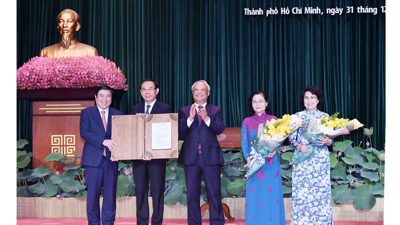 Phó Chủ tịch Quốc hội Uông Chu Lưu trao Nghị quyết của Ủy ban Thường vụ Quốc hội về việc sắp xếp các đơn vị hành chính cấp huyện, cấp xã và thành lập TP Thủ Đức thuộc TPHCM cho lãnh đạo TPHCM. Ảnh: VIỆT DŨNG