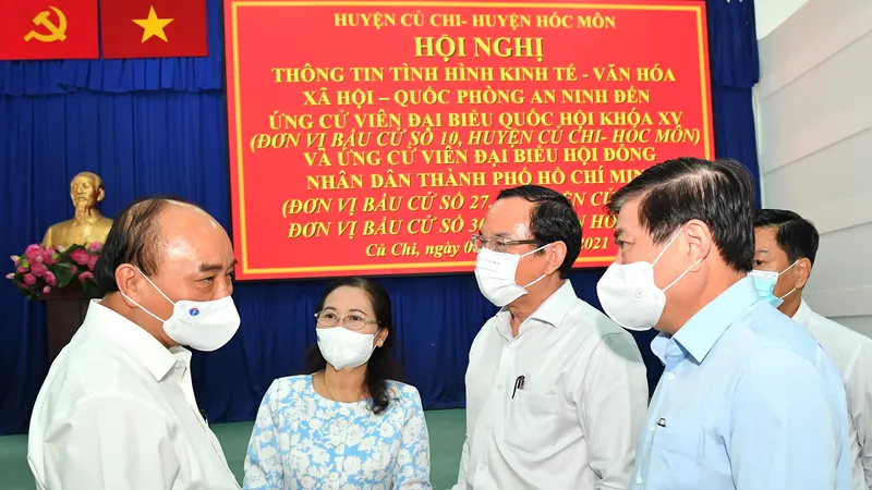 Chủ tịch nước Nguyễn Xuân Phúc trao đổi cùng các đồng chí lãnh đạo TPHCM tại hội nghị. Ảnh: VIỆT DŨNG
