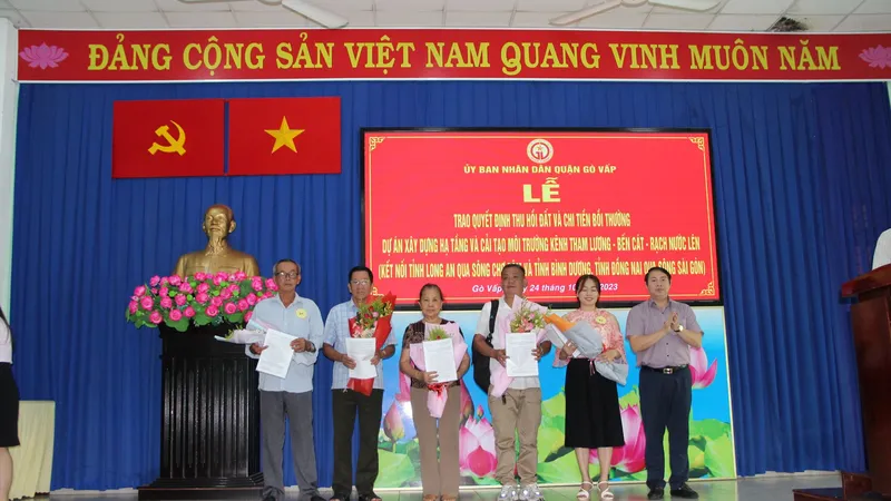 Chủ tịch UBND quận Gò Vấp Nguyễn Trí Dũng trao quyết định và hoa cho các hộ dân