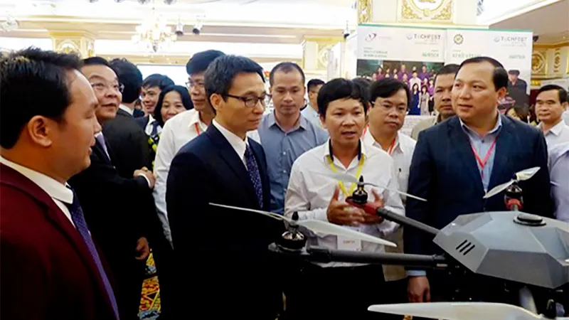 Phó Thủ tướng Vũ Đức Đam và lãnh đạo các bộ ngành tham quan, nghe giới thiệu về dự án thiết bị bay siêu nhẹ ứng dụng cho sản xuất nông nghiệp công nghệ cao. Ảnh: TRẦN BÌNH