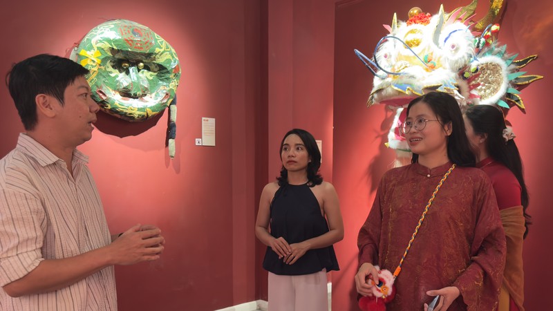 刘金钟与参观者交流，介绍展出的传统龙狮头。