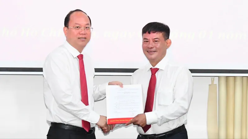 Phó Bí thư Thường trực Thành ủy TPHCM Nguyễn Hồ Hải trao quyết định cho đồng chí Lê Kim Hiếu. Ảnh: VIỆT DŨNG 