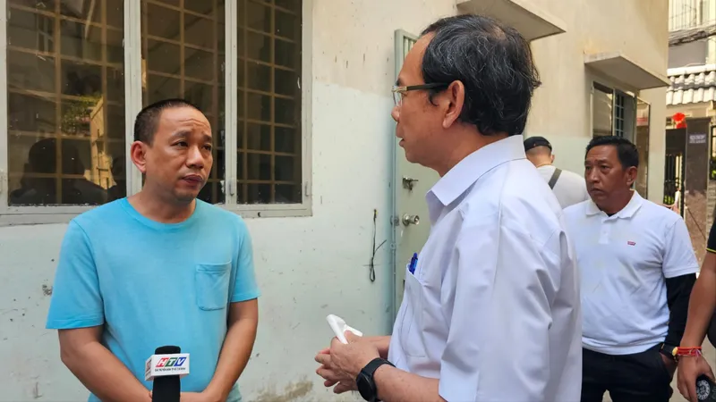 Bí thư Thành ủy TPHCM Nguyễn Văn Nên thăm, động viên gia đình có nhà bị cháy. Ảnh: THU HOÀI 