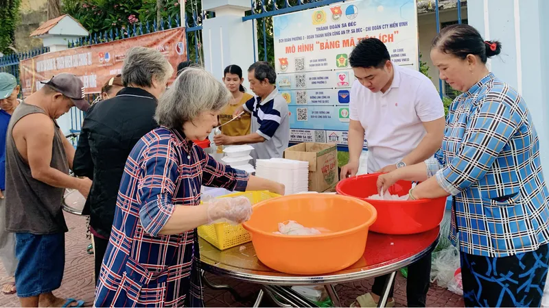 Anh Ngô Văn Quí (thứ 2 từ phải sang) chuẩn bị những suất ăn 0 đồng trao đến người nghèo