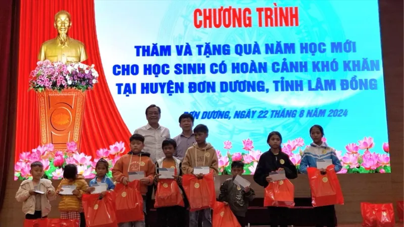 Phó Bí thư Thường trực Đảng ủy Khối Doanh nghiệp TPHCM Đỗ Văn Tuấn và đại diện Huyện ủy Đơn Dương trao quà các em học sinh