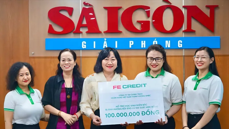 Bà Bùi Thị Hồng Sương - Phó Tổng Biên tập Báo SGGP (giữa) tiếp nhận 100 triệu đồng từ đại diện FE CREDIT. Ảnh: VIỆT NGA