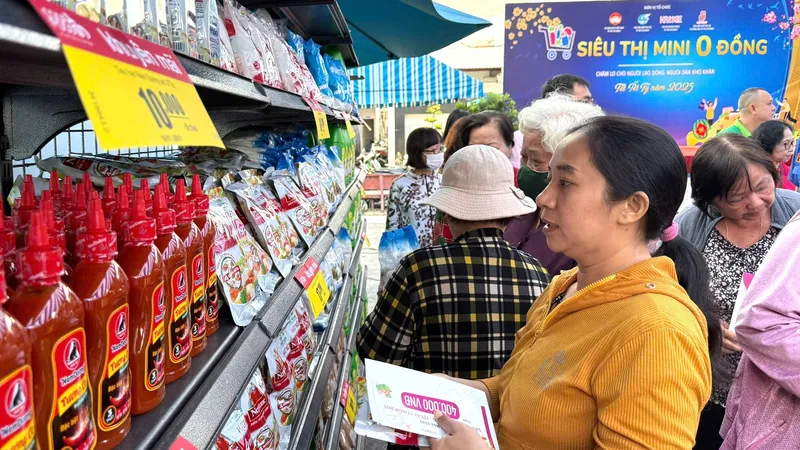 Chị em phụ nữ khó khăn chọn mua hàng tết tại "Siêu thị mini 0 đồng" sáng 17-1