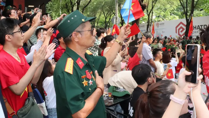 Người dân tại khu vực chợ Bến Thành dõi theo Lễ kỷ niệm 50 năm Ngày Giải phóng miền Nam, thống nhất đất nước. Ảnh: CẨM TUYẾT