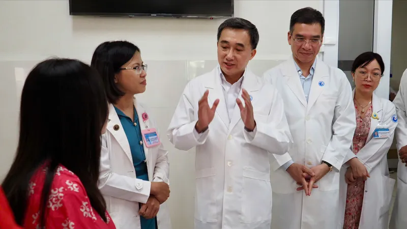 Thứ trưởng Bộ Y tế Trần Văn Thuấn trao tặng hoa và bằng khen cho ekip thực hiện ca can thiệp bào thai cho sản phụ người Singapore Ảnh: HOÀNG HÙNG