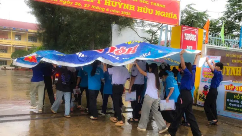 Dầm mưa hỗ trợ thí sinh đến điểm thi