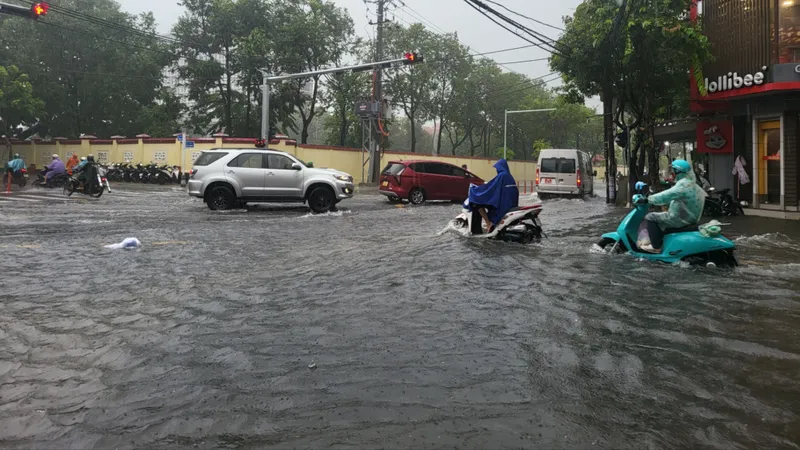 Xe cộ chật vật di chuyển trong dòng nước cuồn cuộn giữa phố Đà Nẵng. Ảnh: XUÂN QUỲNH
