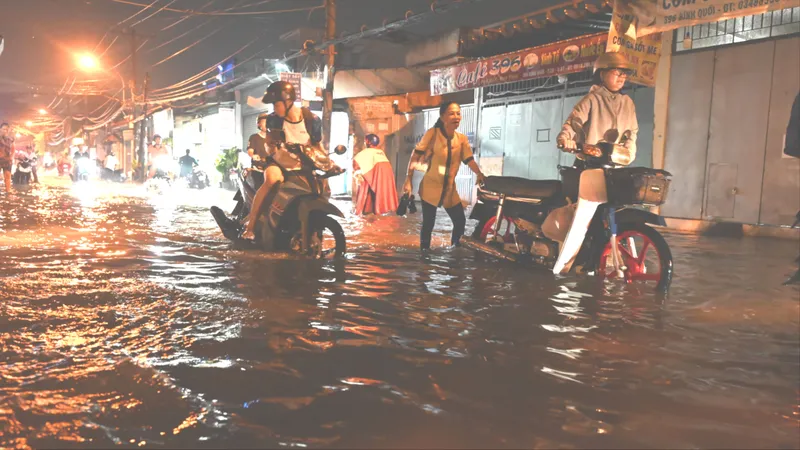 Triều cường dâng cao, người dân bì bõm lội nước về nhà