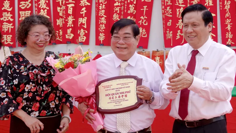 Phó Tổng Biên tập Báo Sài Gòn Giải Phóng Nguyễn Ngọc Anh và Phó Chủ tịch Thường trực Hội Văn học nghệ thuật các dân tộc thiểu số TPHCM tặng Kỷ niệm chương cho Trưởng Ban Quản trị Hội quán Nhị Phủ Bành Huy Cường. Ảnh: THÚY BÌNH