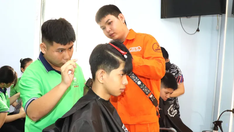 Anh Nguyễn Tuấn Thanh (phải) hướng dẫn em Lê Hữu Đạt nghề cắt tóc. Ảnh: THÁI PHƯƠNG