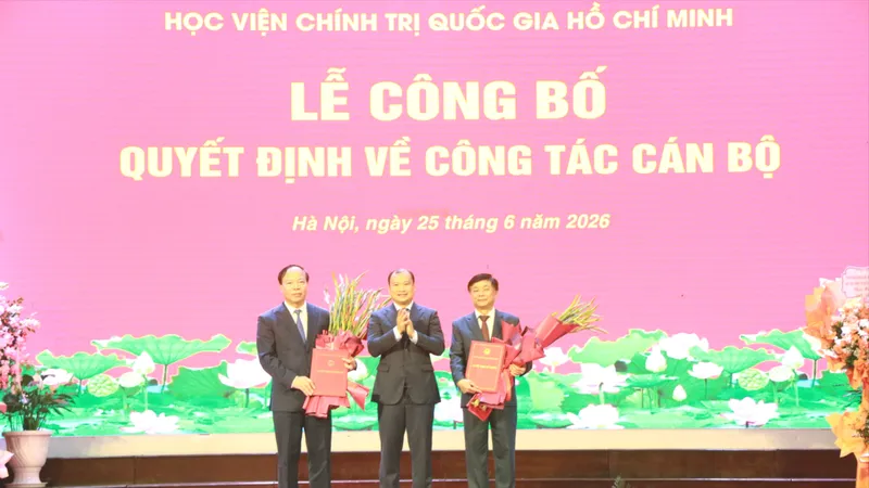 PGS-TS Lê Hải Bình trao quyết định và tặng hoa chúc mừng lãnh đạo Học viện Báo chí và Tuyên truyền. Ảnh: HVBC