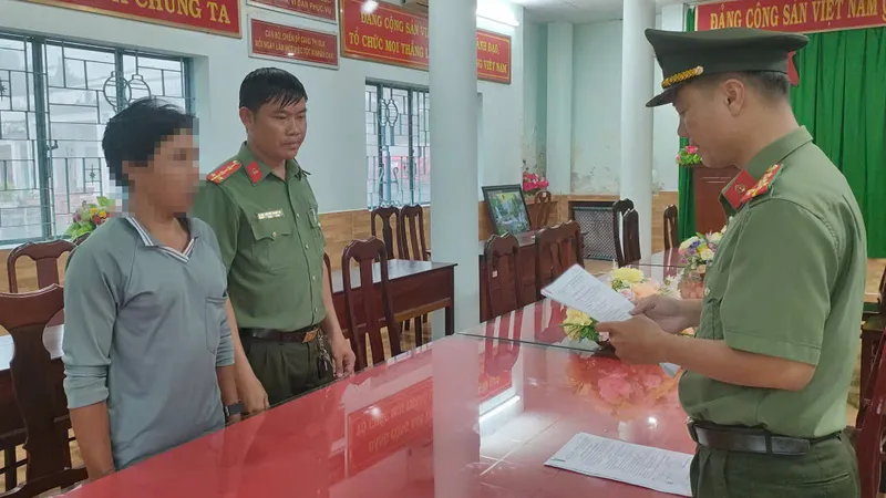 Điều tra viên tống đạt Quyết định khởi tố vụ án, khởi tố bị can, thực hiện lệnh bắt bị can để tạm giam đối với Giang Chí Hùng. Ảnh: CACC