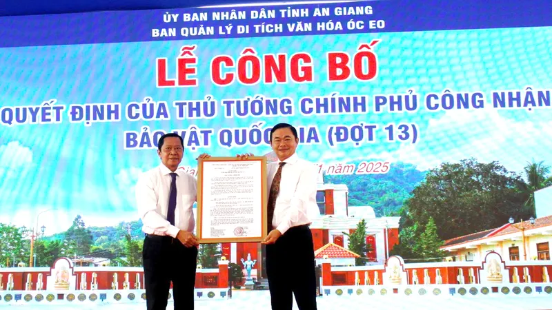 Ông Nguyễn Khánh Hiệp (bên trái), Giám đốc Sở Văn hóa và Thể thao tỉnh An Giang trao quyết định của Thủ tướng Chính phủ về việc công nhận Bảo vật quốc gia đối với 2 di tích Mộ vò Gò Cây Trâm và Đầu tượng phật Linh Sơn Bắc