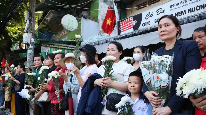 Residents bring white flower to bid farewell to 731 martyrs at Le Thi Rieng Park