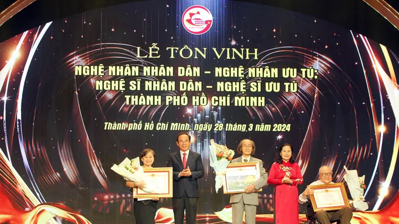 Bí thư Thành ủy TPHCM Nguyễn Văn Nên và Chủ tịch HĐND TPHCM Nguyễn Thị Lệ trao bằng chứng nhận cho các NSND. Ảnh: DŨNG PHƯƠNG