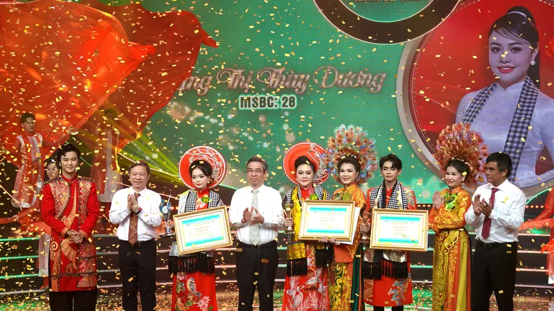 Phó Bí thư Thành ủy, Chủ tịch UBMTTQ Việt Nam TPHCM Nguyễn Phước Lộc, Trưởng Ban Tuyên giáo và Dân vận Thành ủy TPHCM Dương Anh Đức và Tổng Giám đốc Đài Truyền hình TPHCM Cao Anh Minh, trao giải thưởng Chuông Vàng cho thí sinh Đặng Thị Thùy Dương và cùng chụp hình với các nghệ sĩ trong ban huấn luyện. Ảnh: THÚY BÌNH