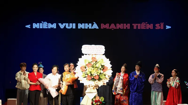 Phó Giám đốc Sở VHTT TPHCM tặng hoa chúc mừng hai đơn vị là Hội Sân khấu TPHCM và Đoàn nghệ sĩ Sân khấu TP Busan, Hàn Quốc đã phối hợp tổ chức biểu diễn thành công vở kịch "Niềm vui nhà Mạnh tiến sĩ". Ảnh: THÚY BÌNH