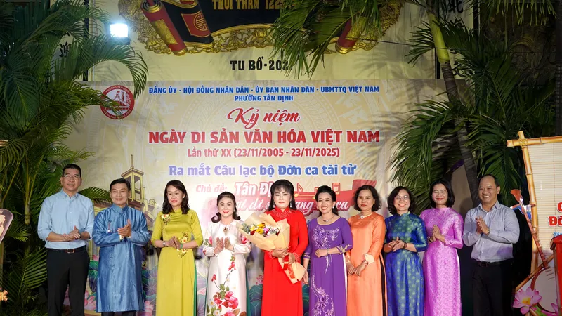 Lãnh đạo phường Tân Định tặng hoa chúc mừng Ban Chủ nhiệm CLB Đờn ca tài tử phường Tân Định. Ảnh: THÚY BÌNH