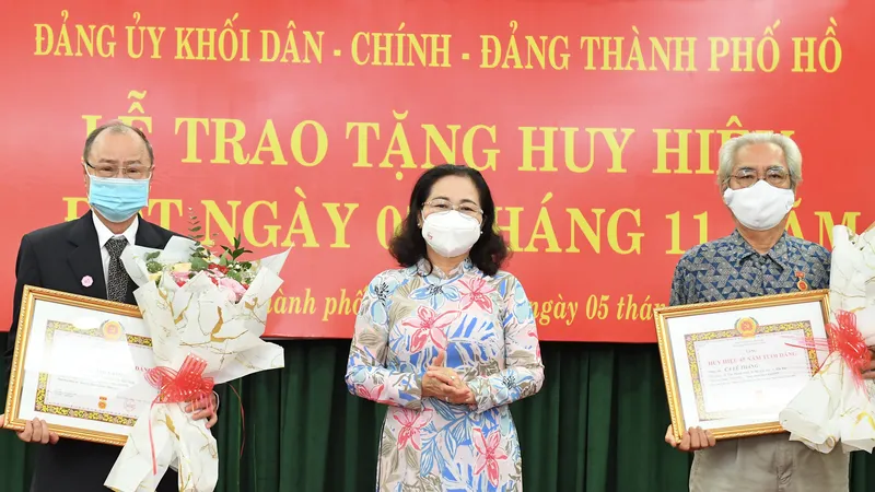 Chủ tịch HĐND TPHCM Nguyễn Thị Lệ trao Huy hiệu 45 năm tuổi Đảng cho đồng chí Ca Lê Thắng và đồng chí Bùi Quang Cảnh. Ảnh: VIỆT DŨNG