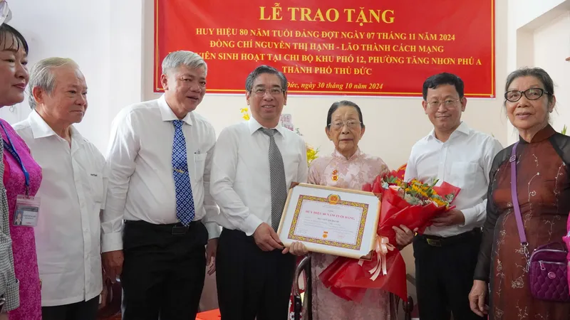 Đồng chí Nguyễn Phước Lộc trao Huy hiệu 80 năm tuổi Đảng đến đồng chí Nguyễn Thị Hạnh