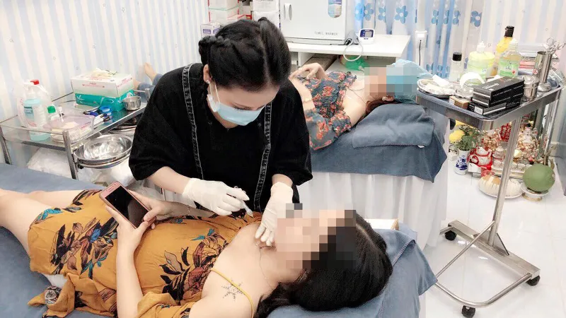 Nhân viên cơ sở thẩm mỹ đang làm đẹp cho khách