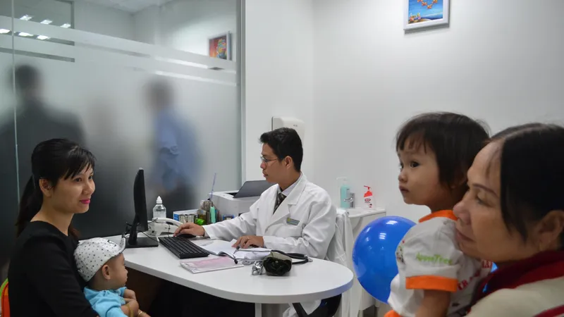 Phụ huynh đưa con đi chích ngừa tại Trung tâm tiêm chủng VNVC 