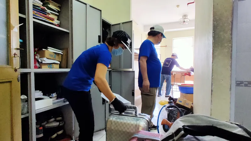 Các thầy cô Trường ĐHQG TPHCM thu dọn toà nhà Công đoàn nhường chỗ cho những người cách ly mới . Ảnh: HOÀNG HÙNG