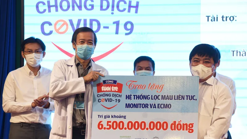 Ông Lê Thế Chữ, Tổng biên tập báo Tuổi Trẻ TPHCM trao bảng tượng trưng món quà bạn đọc báo gửi tới Bệnh viện Bệnh Nhiệt đới TPHCM Ảnh: DUYÊN PHAN