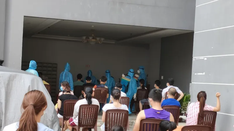 Nhân viên y tế lấy mẫu cho người dân sinh sống tại chung cư có ca nghi mắc Covid-19