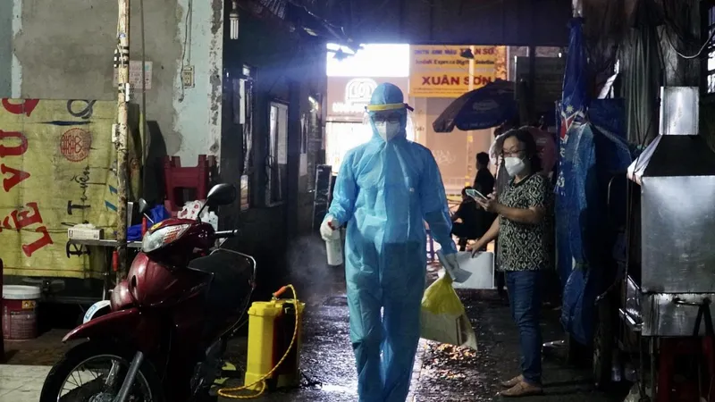 Nhân viên y tế phun khử khuẩn con một hẻm trên địa bàn quận 1