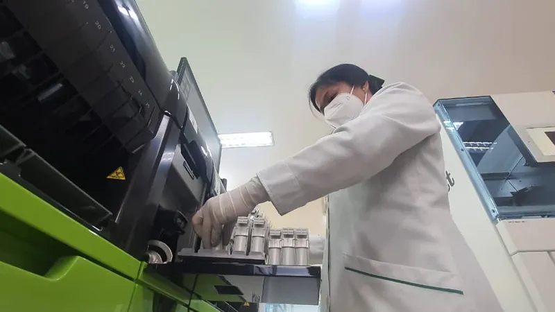 Nhân viên y tế đang thao tác trên hệ thống xét nghiệm tự động hoàn toàn 