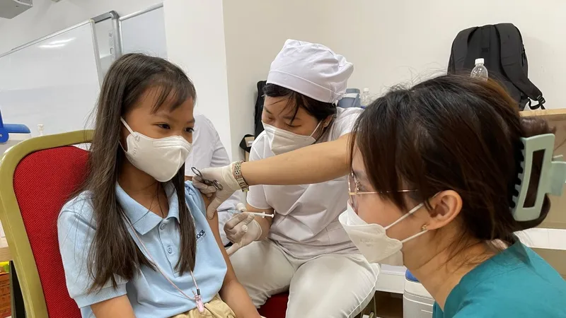 Nhân viên y tế tiêm vaccine cho trẻ em