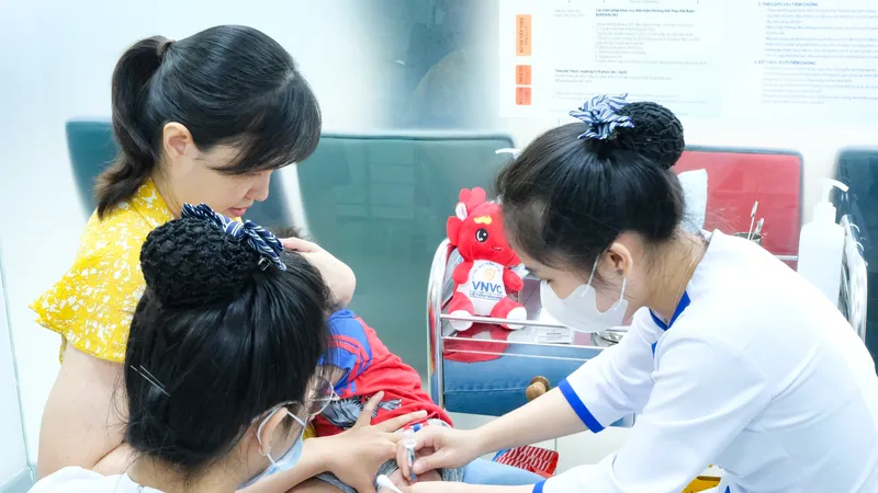 Phụ huynh đưa con đến tiêm chủng vaccine viêm màng não mô cầu tại VNVC