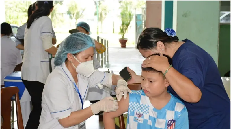 Nhân viên y tế tiêm vaccine cho trẻ